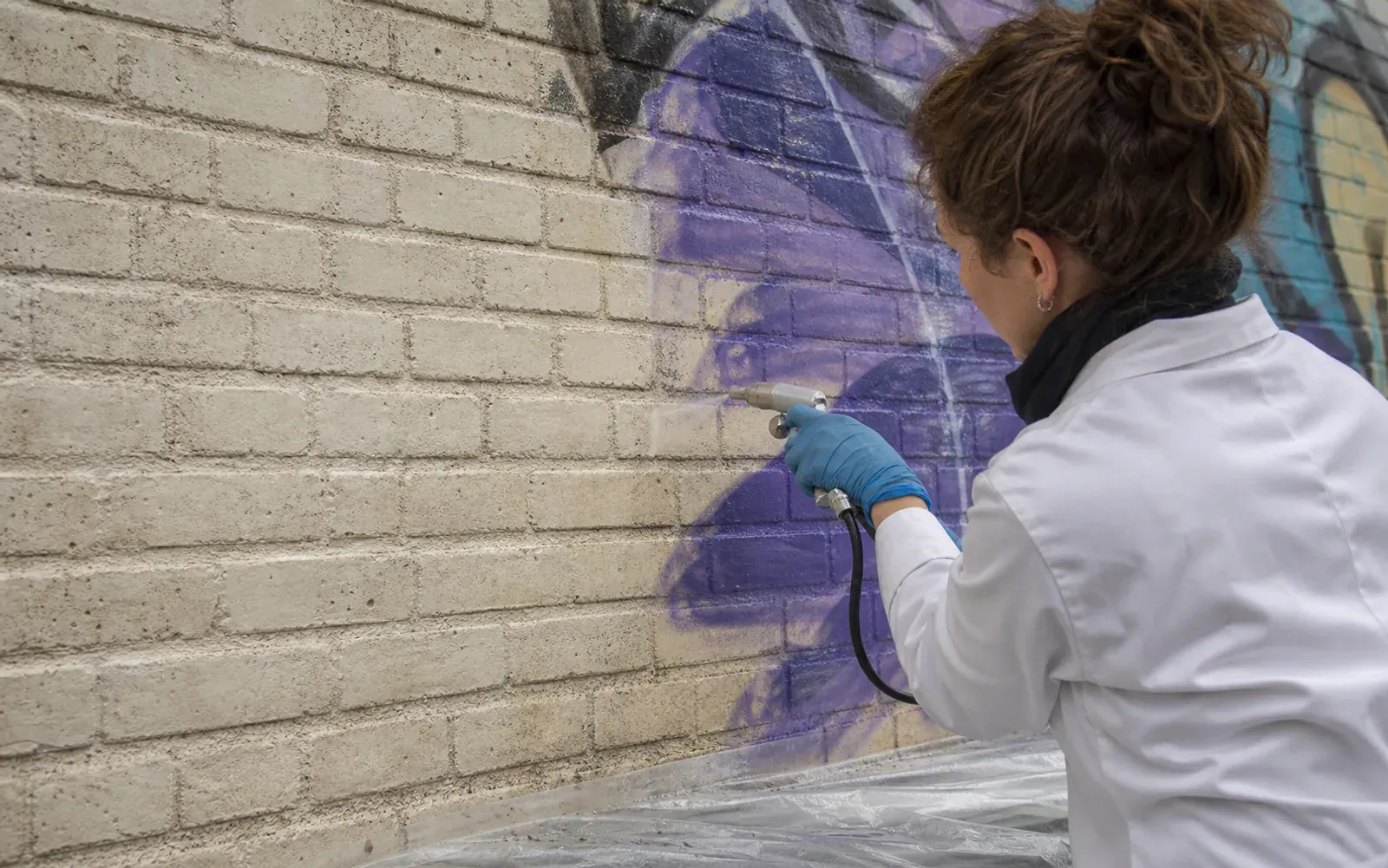 Rimozione di graffiti da una parete in mattone